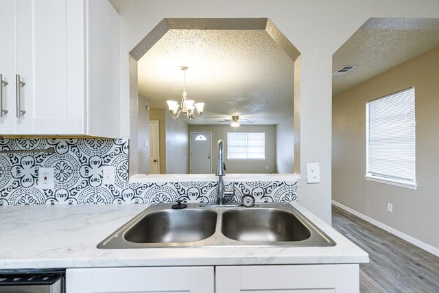 kitchen featuring tasteful backsplash, sink, a textured ceiling, and white cabinets