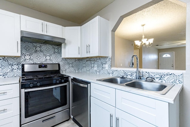 kitchen with pendant lighting, sink, appliances with stainless steel finishes, white cabinetry, and tasteful backsplash