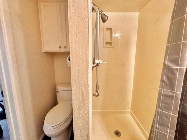 bathroom with toilet and a shower