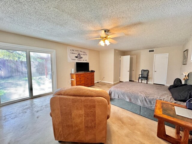 living room with ceiling fan and a textured ceiling