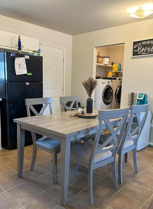 tiled dining area featuring washing machine and clothes dryer and a textured ceiling