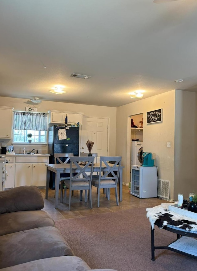 living room with washer / dryer and light tile patterned floors