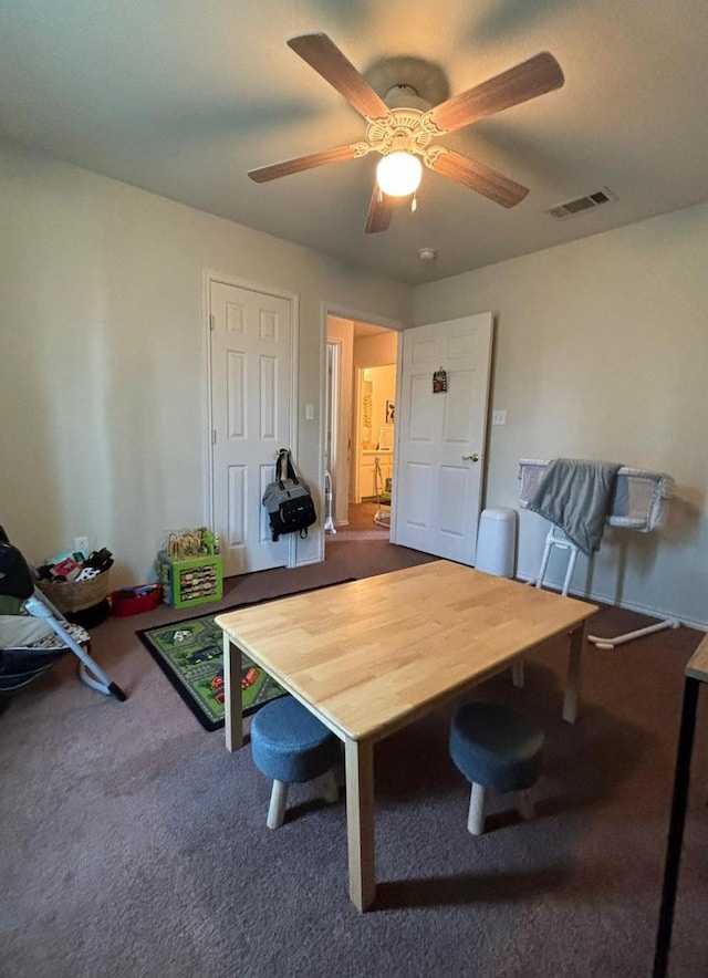 carpeted home office featuring ceiling fan