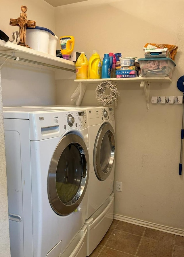 clothes washing area featuring dark tile patterned flooring and independent washer and dryer