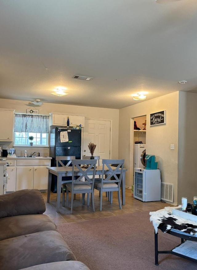 tiled living room with washer / clothes dryer and sink