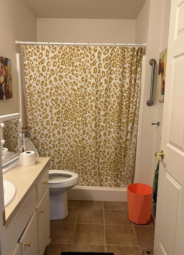 bathroom with tile patterned flooring, vanity, toilet, and walk in shower