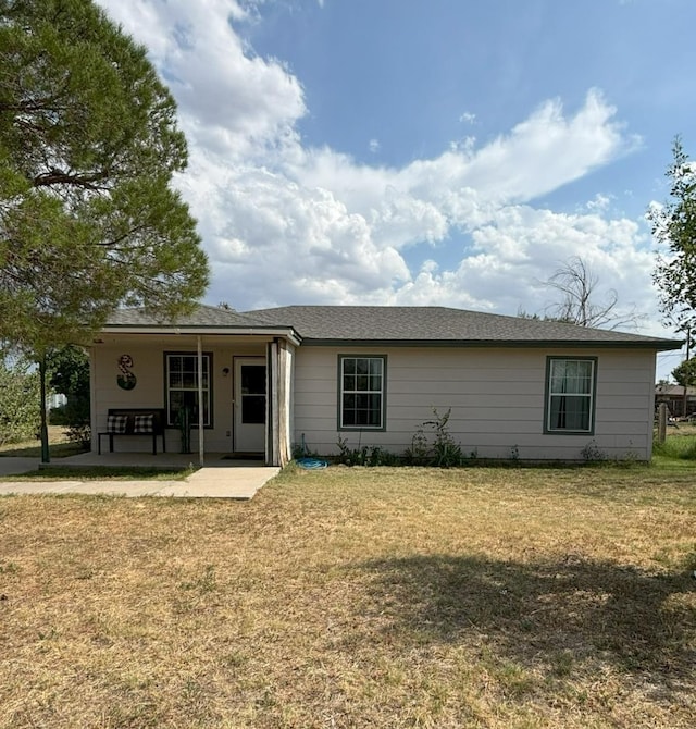 rear view of property with a yard and a patio area