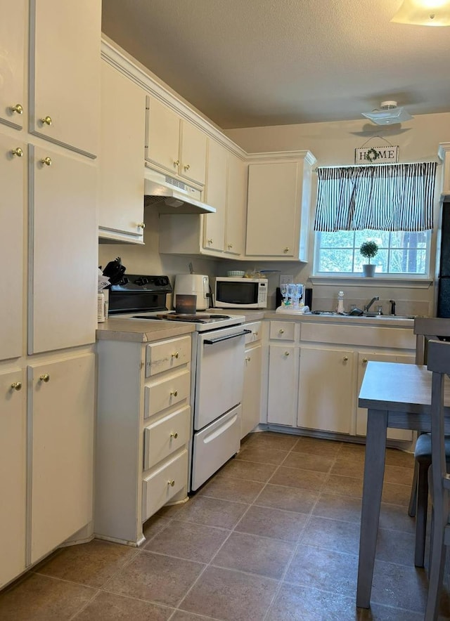 kitchen with sink, white cabinets, tile patterned flooring, electric range, and a textured ceiling