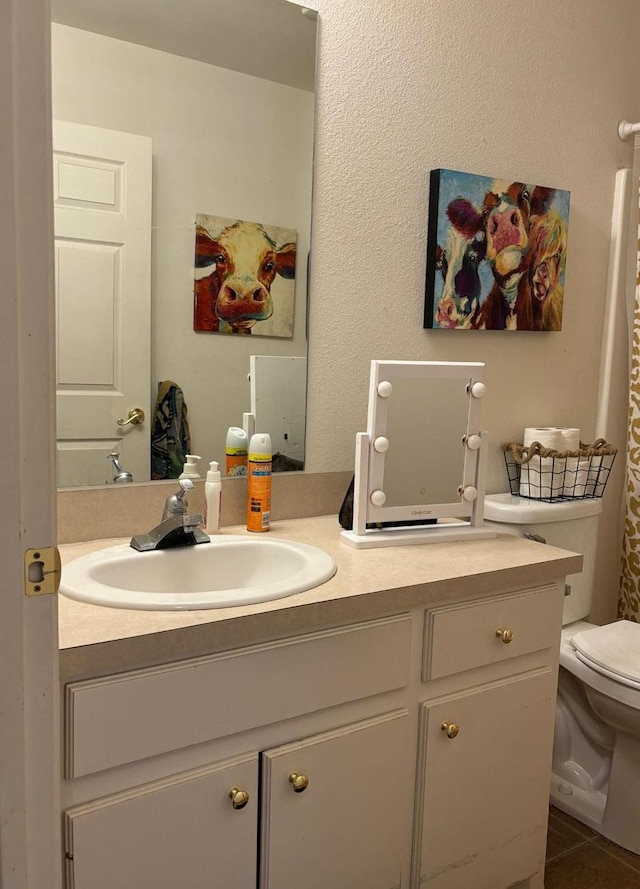 bathroom featuring vanity, tile patterned floors, and toilet