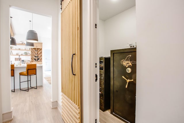 corridor featuring a barn door and light hardwood / wood-style floors