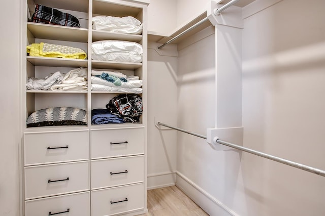 spacious closet with light hardwood / wood-style flooring