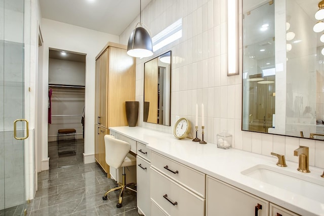 bathroom with tile walls, vanity, backsplash, and walk in shower