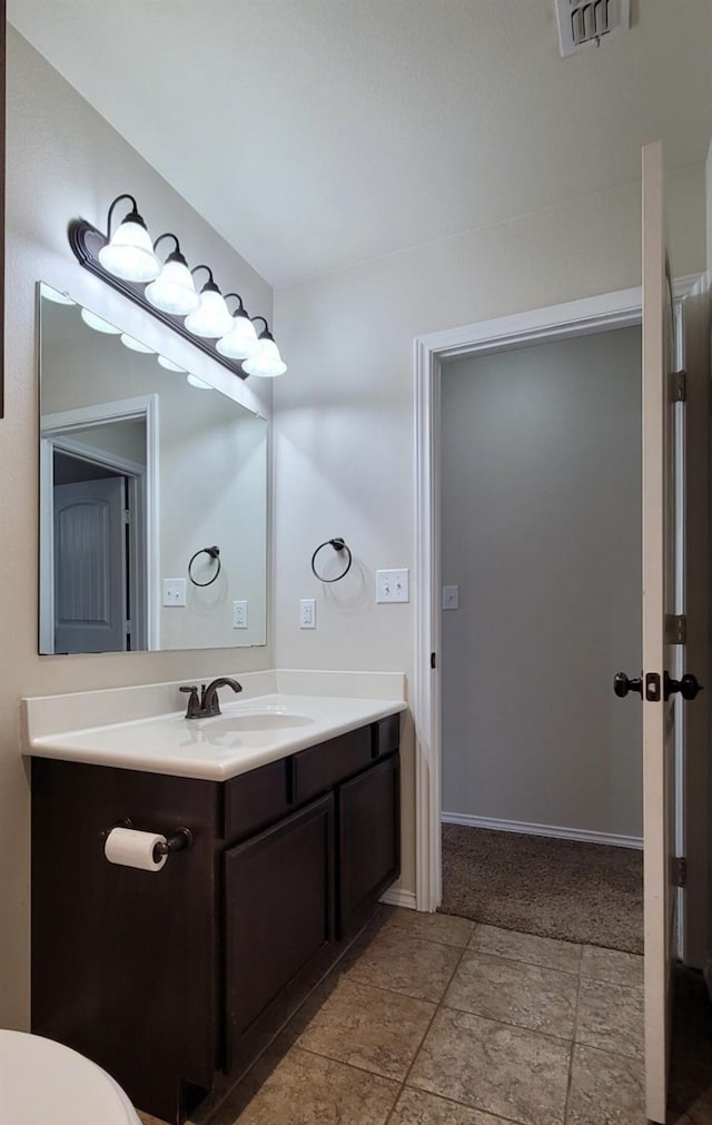 bathroom with toilet, visible vents, and vanity