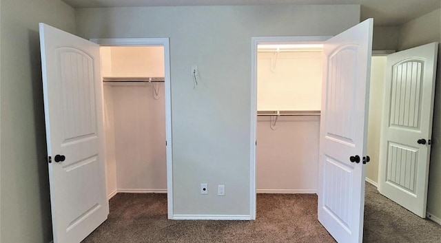 unfurnished bedroom featuring a walk in closet, baseboards, and carpet