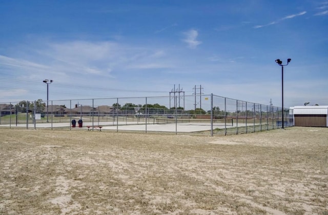 surrounding community featuring a tennis court and fence