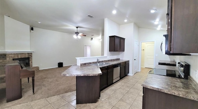 kitchen featuring stainless steel appliances, dark brown cabinets, a sink, visible vents, and a peninsula