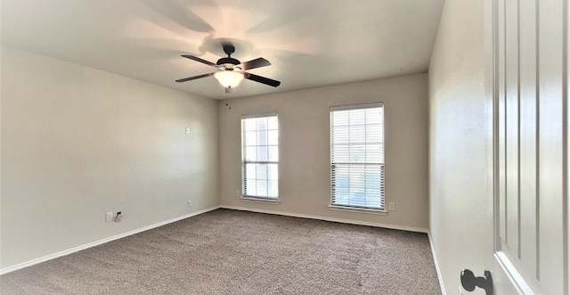 spare room with a ceiling fan, dark carpet, and baseboards