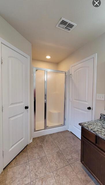 full bath with visible vents, a shower stall, tile patterned flooring, and vanity