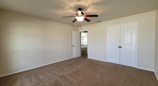 unfurnished bedroom featuring visible vents, a closet, carpet flooring, and baseboards
