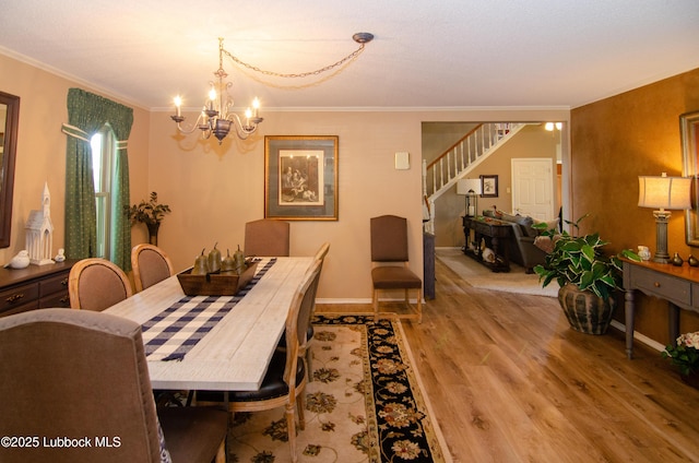 12220 Chicago Ave, Lubbock, TX 79424 - dining room featuring a chandelier, light wood finished floors, ornamental molding, and stairs