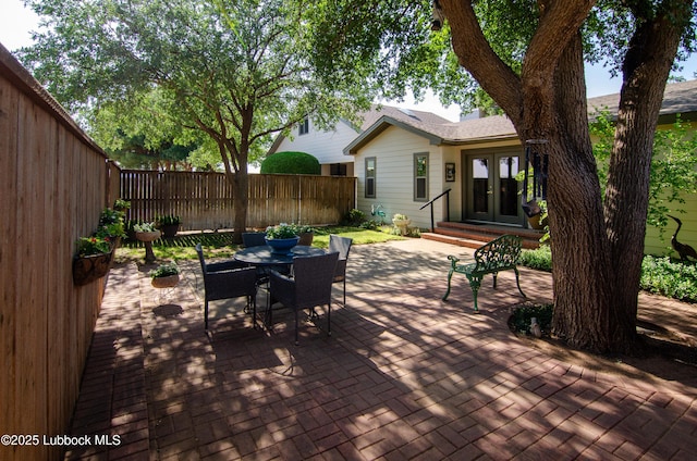12220 Chicago Ave, Lubbock, TX 79424 - wooden terrace with french doors, a patio, a fenced backyard, and outdoor dining area