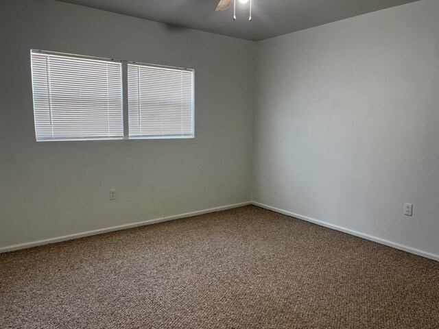 carpeted empty room featuring ceiling fan