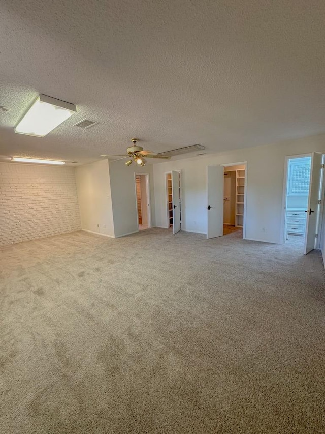 unfurnished room with ceiling fan, carpet floors, and a textured ceiling