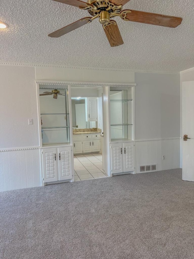 carpeted spare room with ceiling fan and a textured ceiling