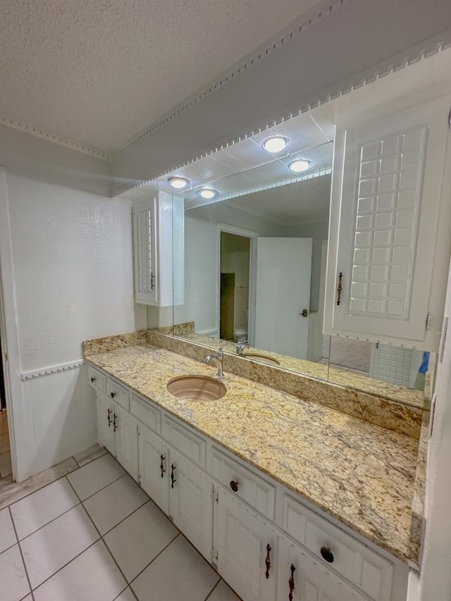 bathroom featuring vanity, tile patterned flooring, and a textured ceiling