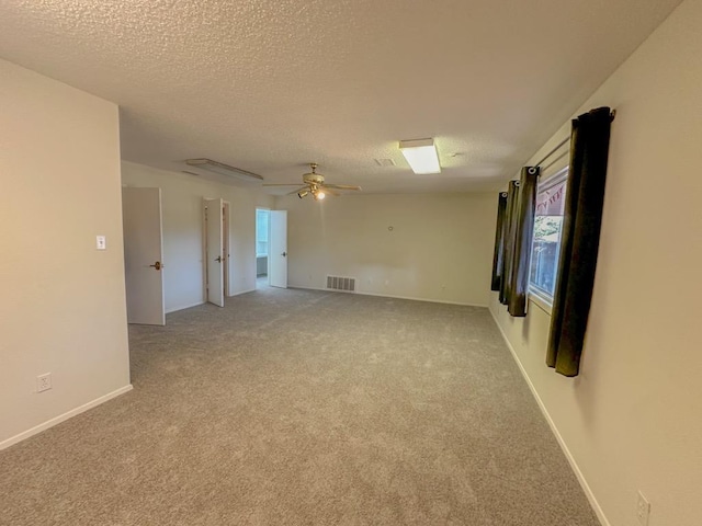 carpeted spare room with ceiling fan and a textured ceiling