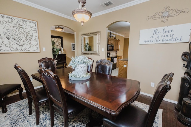 4906 Grinnell St, Lubbock, TX 79416 - dining area with arched walkways, crown molding, wood finished floors, and baseboards
