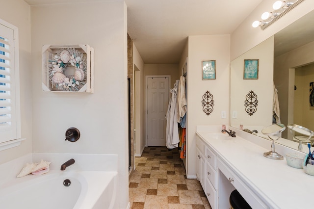 4906 Grinnell St, Lubbock, TX 79416 - bathroom with vanity, a bath, stone finish flooring, and baseboards