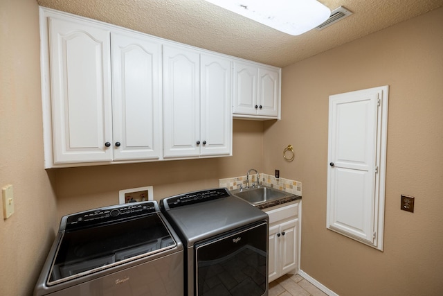 544 S US Highway 87, Wilson, TX 79381 - laundry room with visible vents, a textured ceiling, separate washer and dryer, a sink, and cabinet space