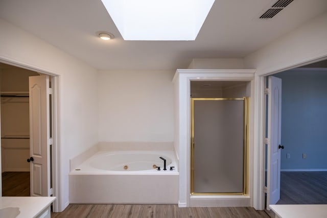 544 S US Highway 87, Wilson, TX 79381 - bathroom with a tub with jets, wood finished floors, a skylight, visible vents, and a stall shower