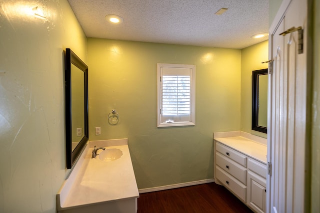 544 S US Highway 87, Wilson, TX 79381 - bathroom featuring a sink, a textured ceiling, wood finished floors, and two vanities