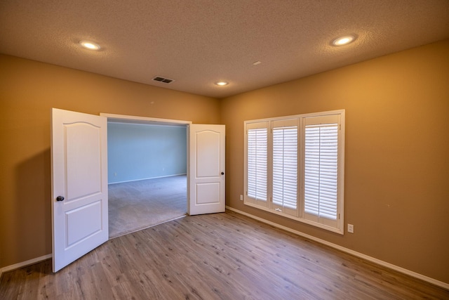 544 S US Highway 87, Wilson, TX 79381 - spare room featuring baseboards, a textured ceiling, and wood finished floors