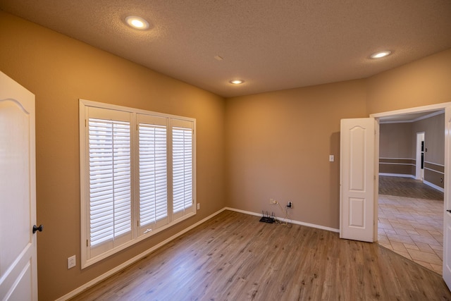 544 S US Highway 87, Wilson, TX 79381 - spare room featuring baseboards, recessed lighting, a textured ceiling, and wood finished floors