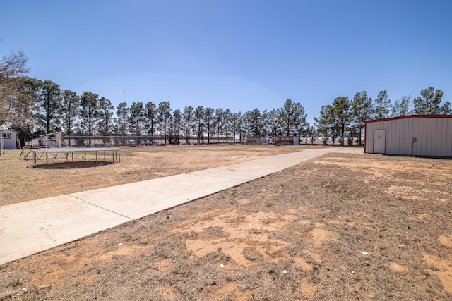 544 S US Highway 87, Wilson, TX 79381 - view of yard with an outdoor structure, a trampoline, and a shed