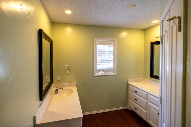 544 S US Highway 87, Wilson, TX 79381 - bathroom with a textured ceiling, two vanities, a sink, and wood finished floors