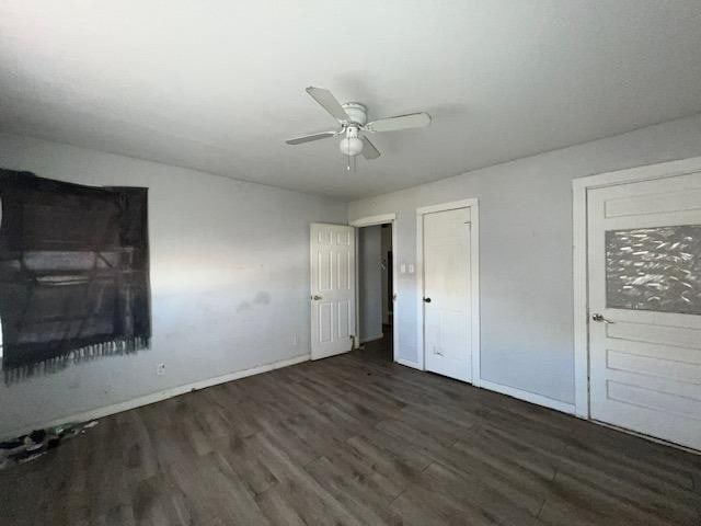 unfurnished bedroom with ceiling fan and dark hardwood / wood-style floors