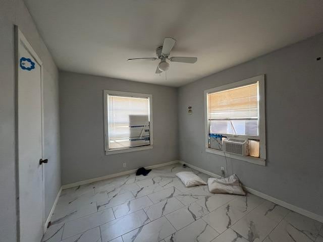 empty room featuring cooling unit and ceiling fan