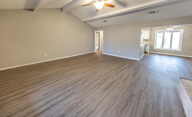 unfurnished living room with lofted ceiling with beams, dark hardwood / wood-style floors, a textured ceiling, and ceiling fan