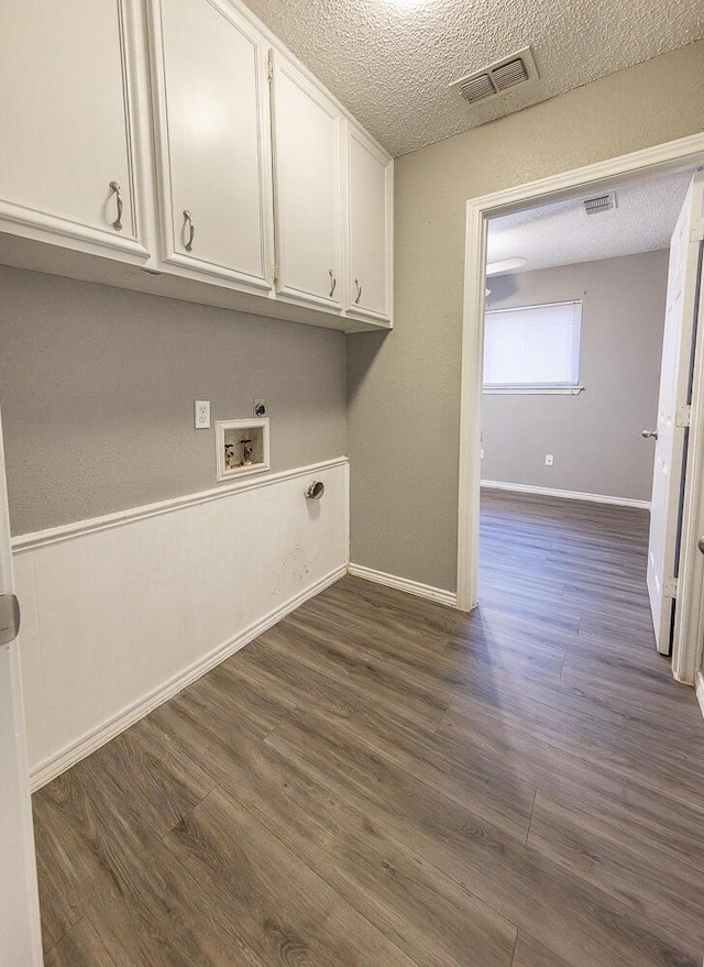 washroom with cabinets, a textured ceiling, dark hardwood / wood-style floors, electric dryer hookup, and washer hookup