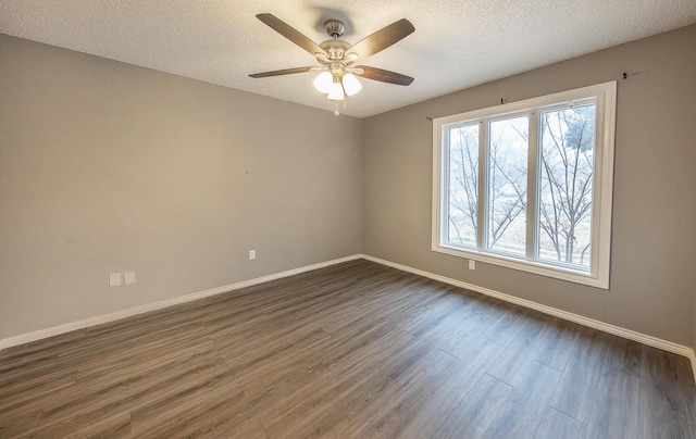 empty room with ceiling fan, dark hardwood / wood-style floors, and a textured ceiling