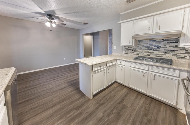 kitchen with dark wood-type flooring, white cabinetry, tasteful backsplash, stainless steel gas cooktop, and kitchen peninsula