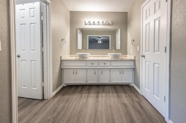 bathroom with hardwood / wood-style flooring, vanity, and a textured ceiling