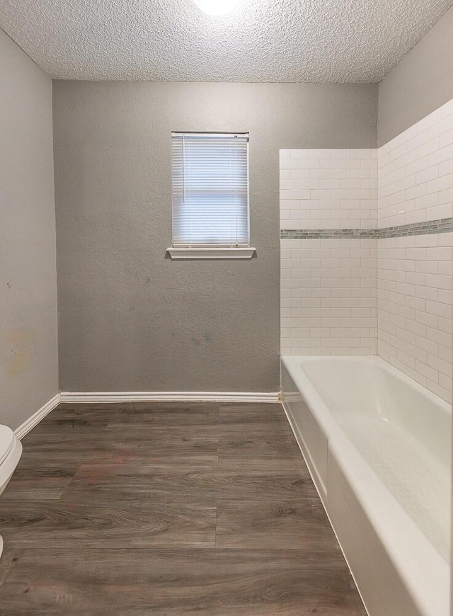 bathroom featuring hardwood / wood-style flooring, a textured ceiling, and toilet