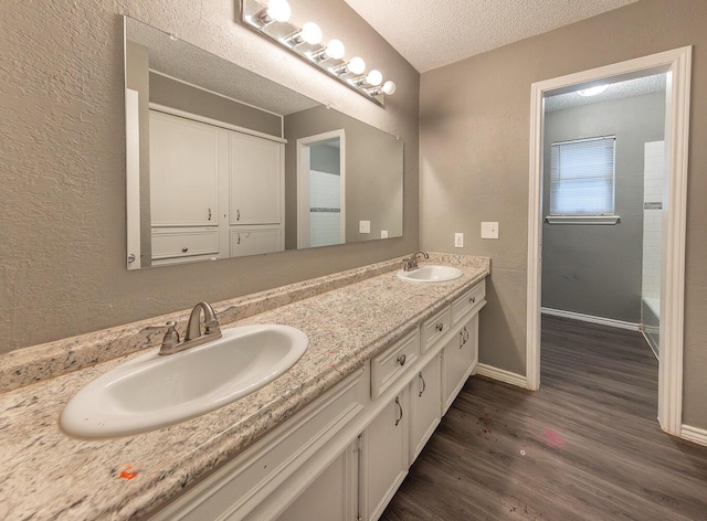 bathroom with vanity, hardwood / wood-style flooring, and a textured ceiling