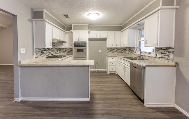 kitchen with sink, white cabinets, dark hardwood / wood-style flooring, ornamental molding, and stainless steel appliances