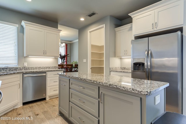 136 Preston Hollow Ln, Wolfforth, TX 79382 - kitchen featuring stainless steel appliances, light wood finished floors, a kitchen island, white cabinetry, and recessed lighting